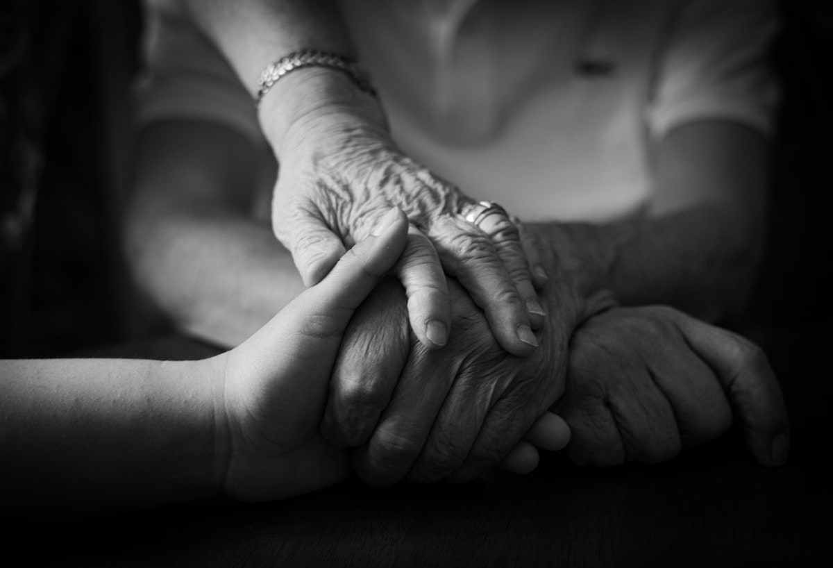 Two hands holding each other with care — Mikey and Holly